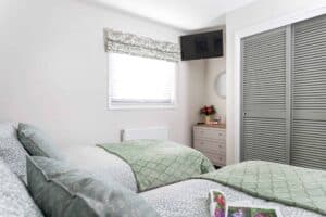 Twin bedroom with TV at Sandmartin Lodge